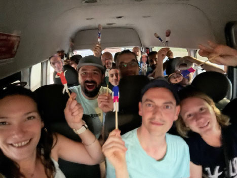 A group of youth participants on a bus, holding their puppet selves.